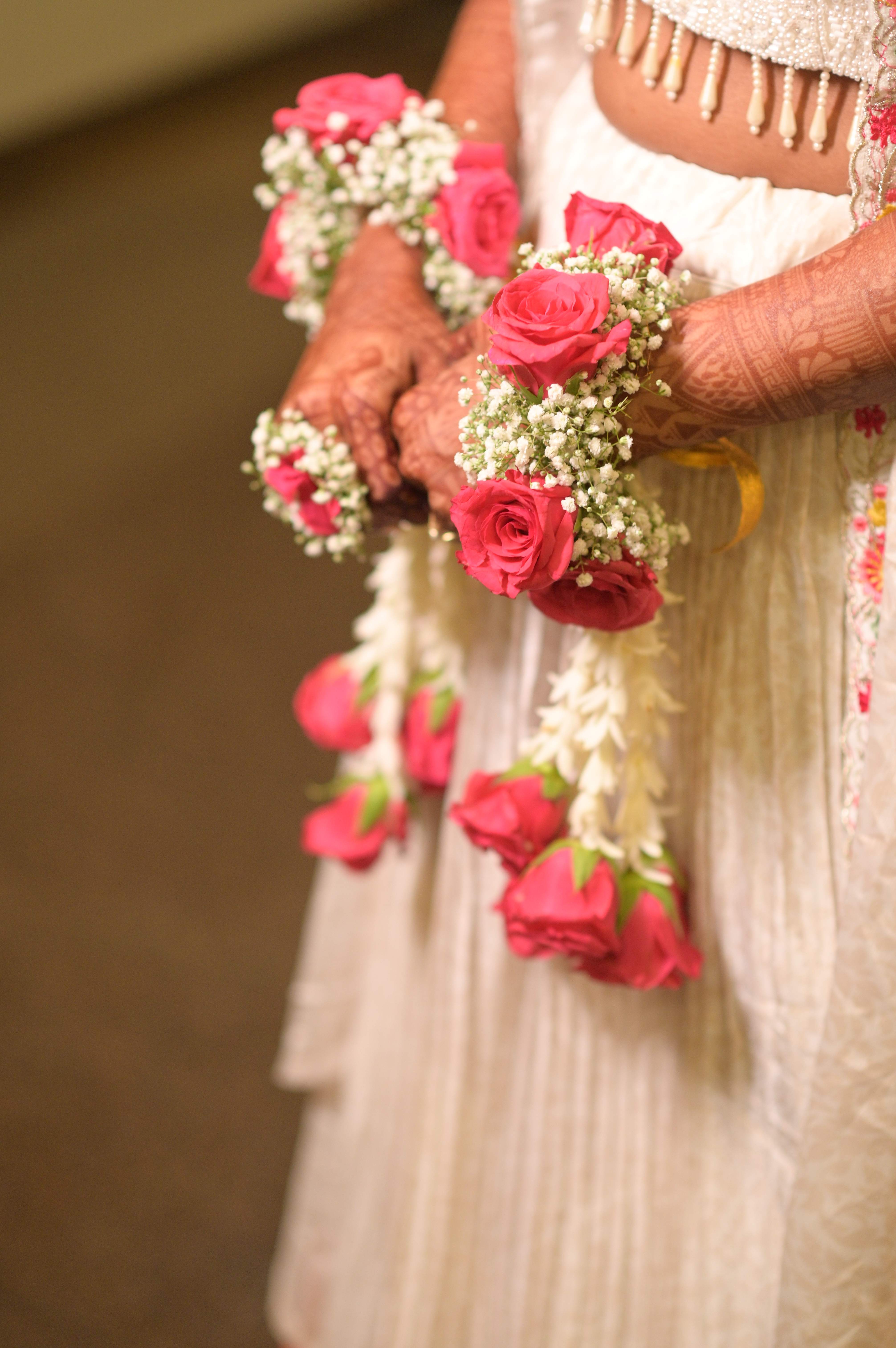 Candid close-up henna decorated hands with rose jewelry