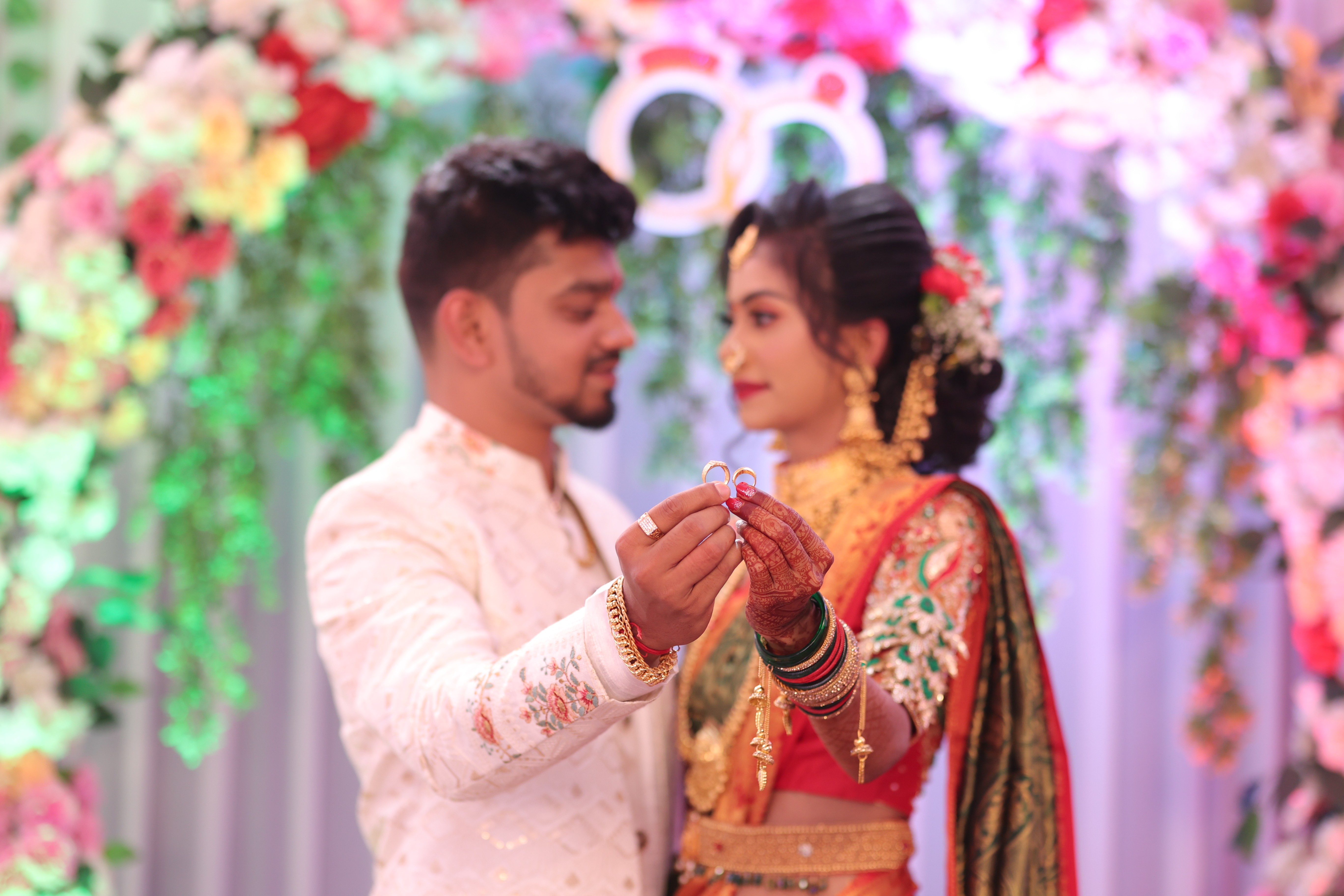 Candid ring exchange ceremony colorful backdrop